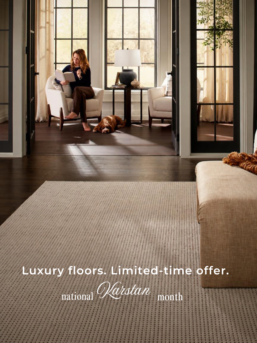 Woman sitting on a hardwood floor with a coffee mug in her hand.